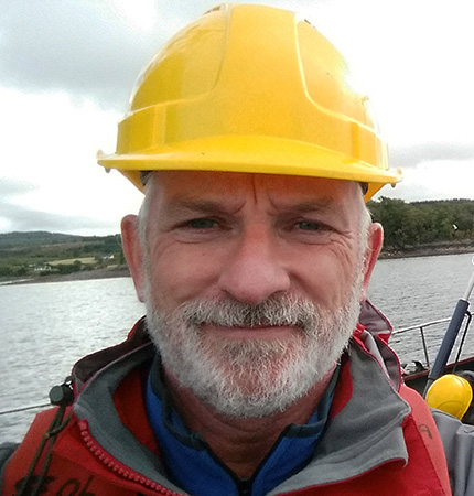 Callum Whyte on a research vessel with hard hat