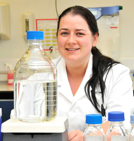 Karen in white lab coat in the laboratory preparing sterile medium for algal cultures.