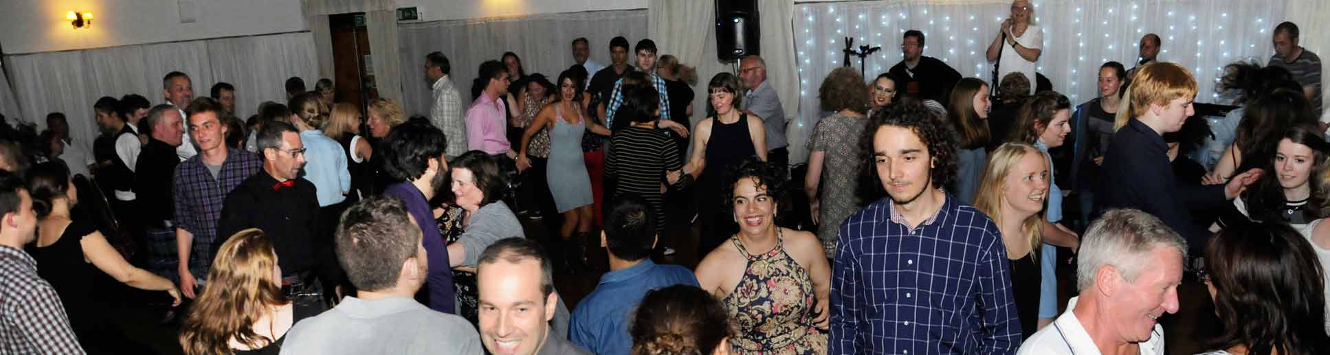 Picture showing very happy crowd of students with their friends, families and lecturers during the graduation ceilidh in the Argyllshire Gathering