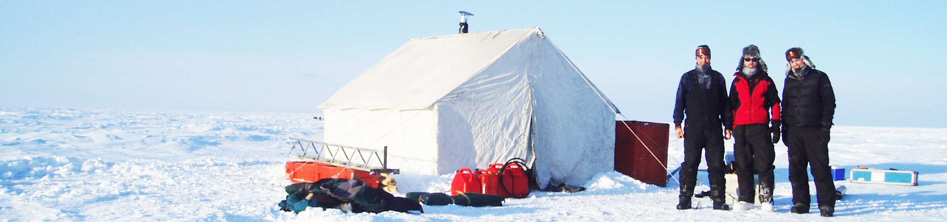 Photo of group of researchers outside a tent in the polar regions, ready to go sampling