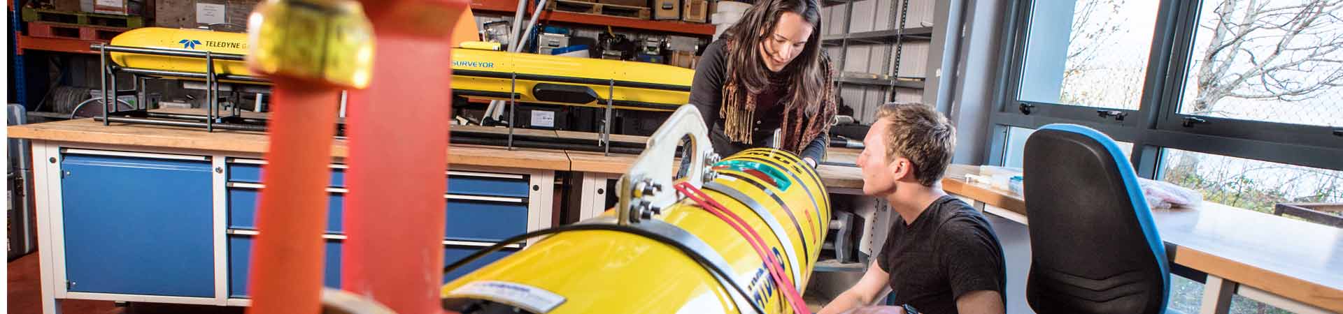 Two technicians working on laptop connected to an autonomous underwater vehicle