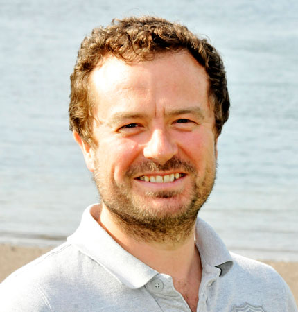 
        Head and shoulder image of Dr Mark Hart outside at the back beach
        