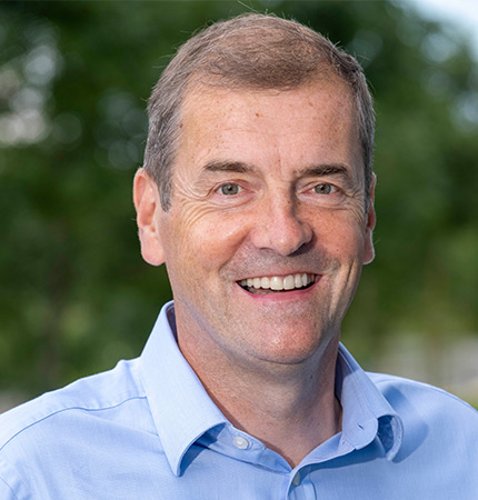 
        Corporate headshot of Adam Christie wearing a blue shirt
        