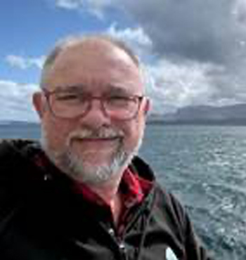A formal head and shoulder photo of trustee Stephen Hall smiling into the camera