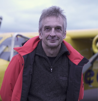 Head and shoulder shot of a smiling Phil Anderson in front of an aeroplane