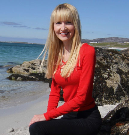 
        Dr Laura Ferguson smiling on a Scottish beach 
        