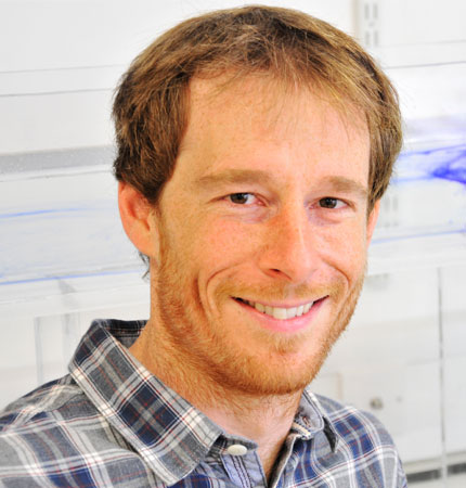 
        Head and shoulder photo of a smiling Dr Sam Jones during a demonstration of his mixing tank
        