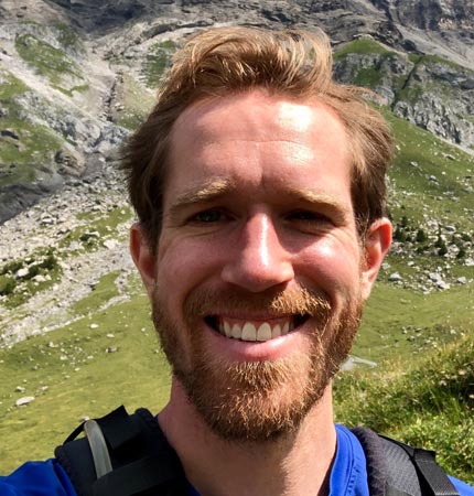 
        Head shot of smiling Dr Tim Szewczyk during a hill walking trip
        