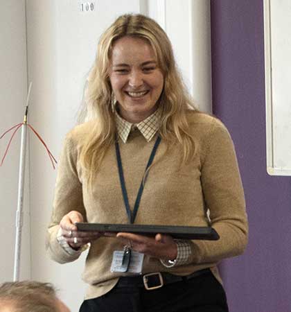 
        Libby Smith during a training session holding a tablet
        