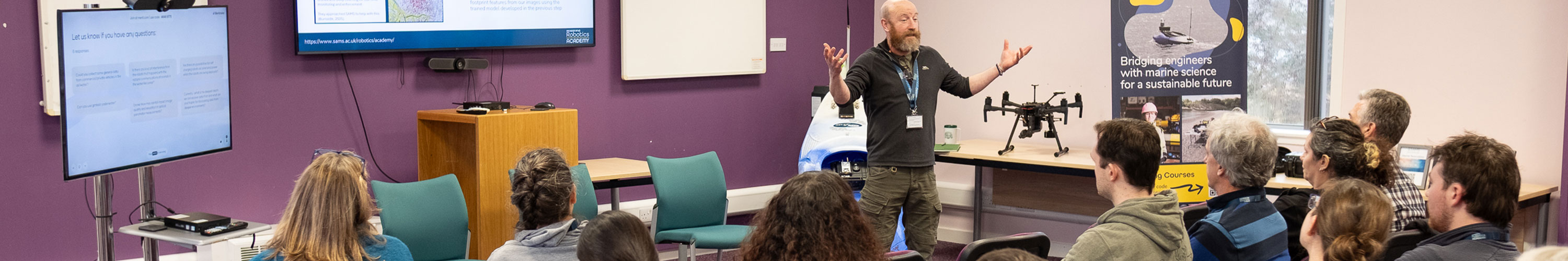 a robotics expert giving a lecture to a room of industry representatives