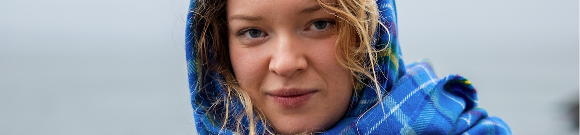 Blond nordic looking woman wearing ocean clan tartan head scarf