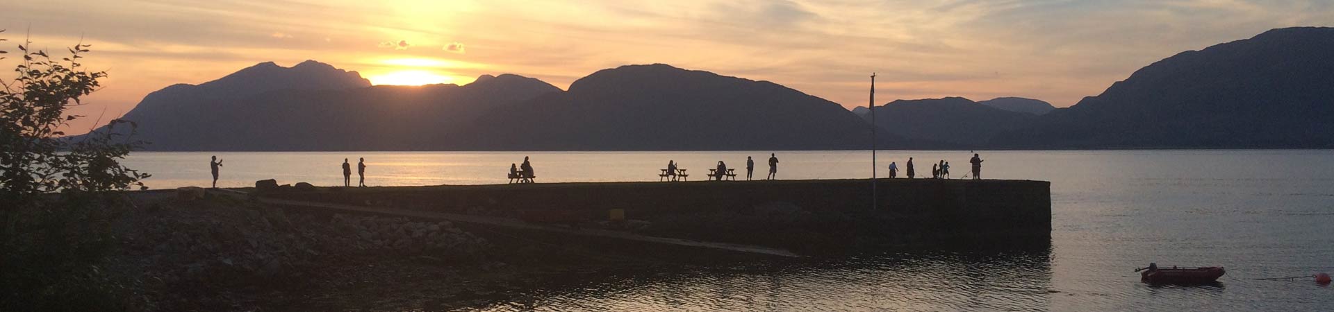 Photo showing a Scottish scene at dusk with people on a pier