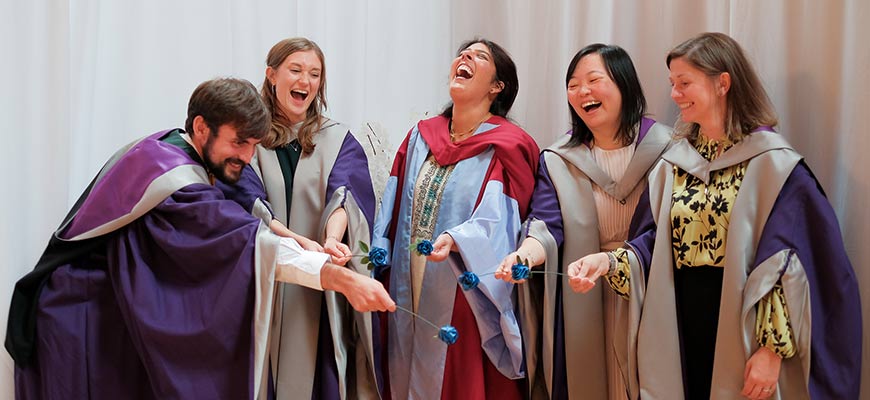 Graduation students laughing in their robes
