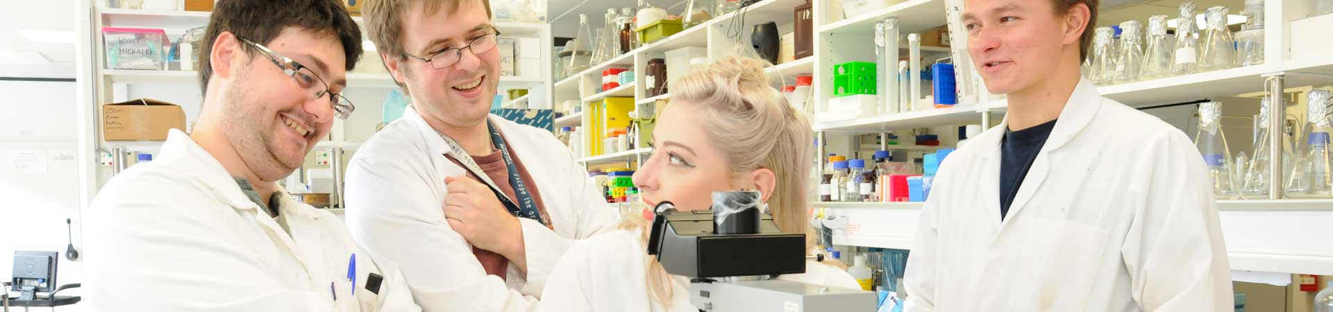 Four Master students in a typical molecular biology laboratory during their course.