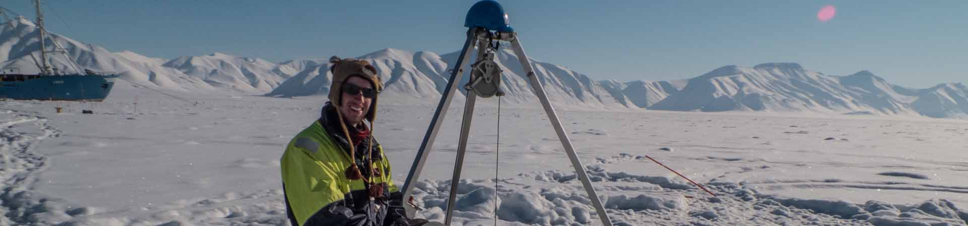 Student collecting samples from below sea ice