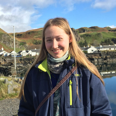 Undergraduate student studying at SAMS in Oban, head and shoulder picture with coastal village in background