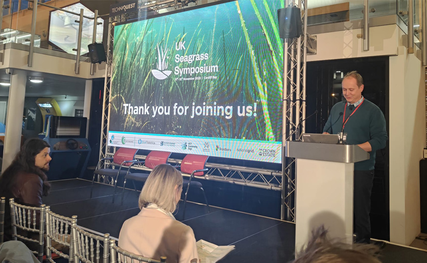 Dr Alasdair O'Dell of SAMS presents at the Seagrass Symposium 2025 as the baton is handed over to SAMS for the next event in 2027