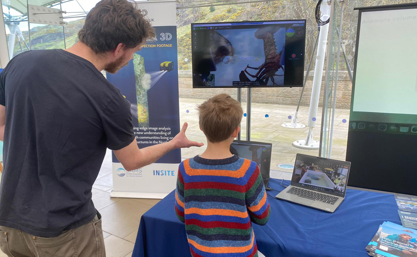 Dr John Halpin helps a young visitor to the NS3D marine robotics stand at Dynamic Earth. 