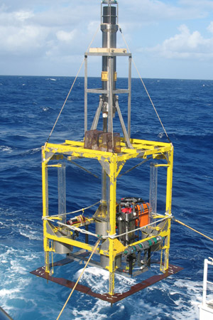 A seabed lander being deployed into the waters above a deep-ocean trench